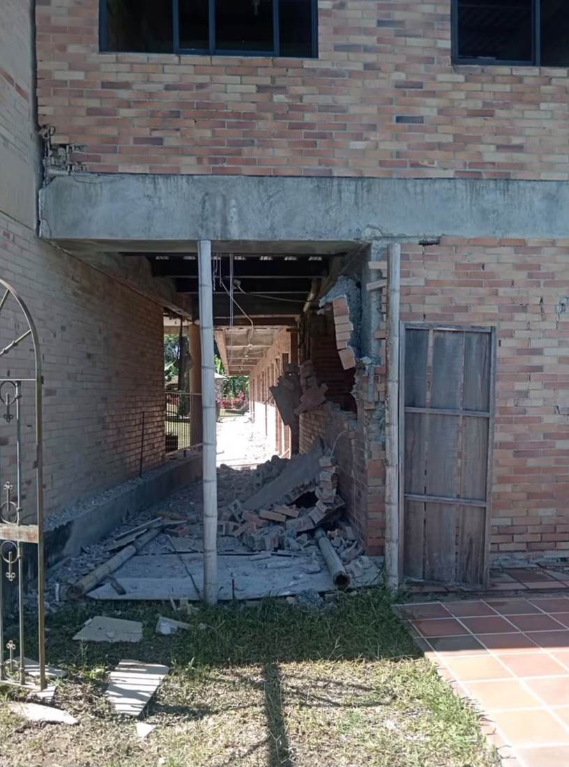 Muro de ladrillo con un boquete abierto por el sismo en Montenegro