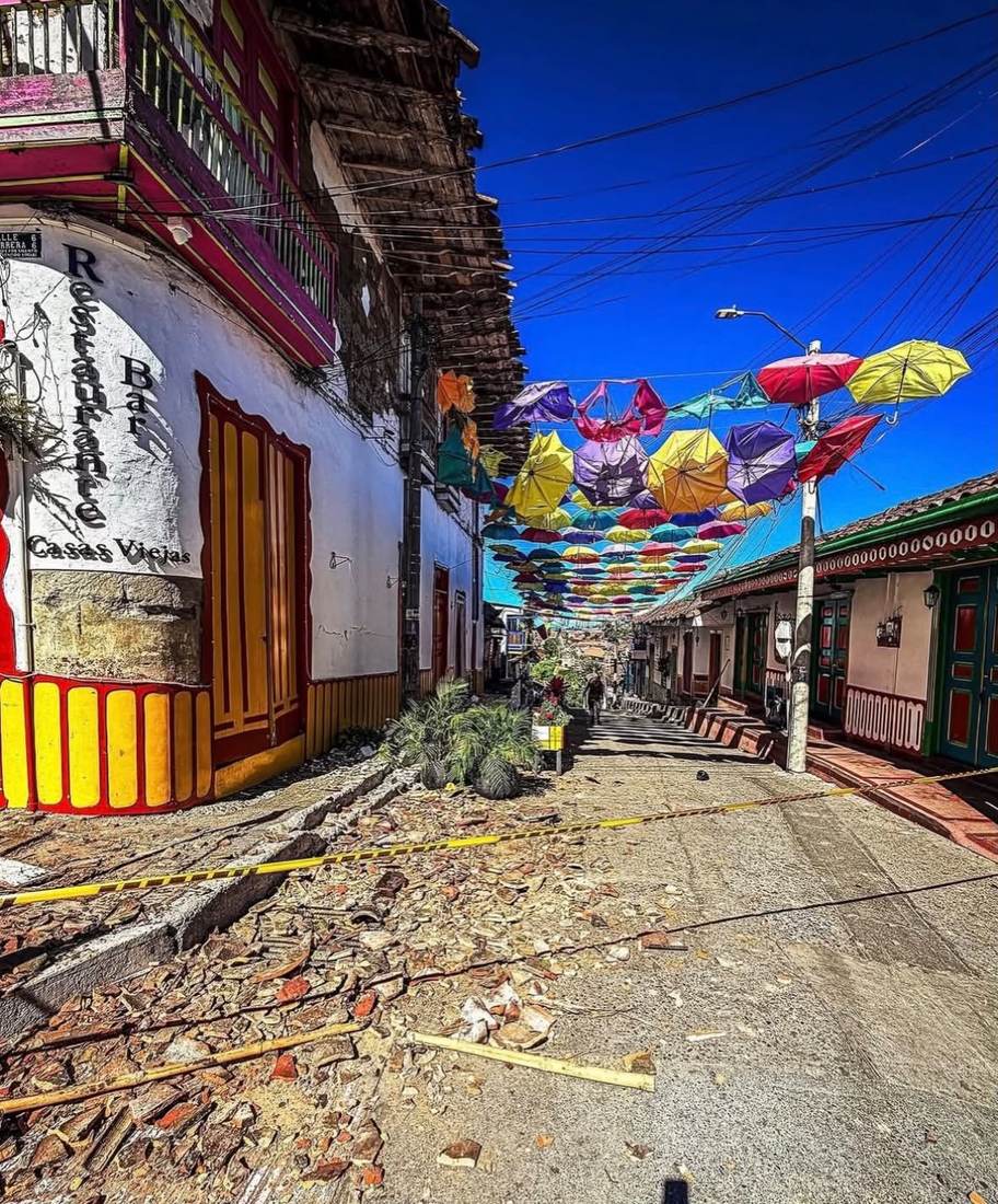 Calle de Salento con banderines de colores y escombros a lo largo de la vía